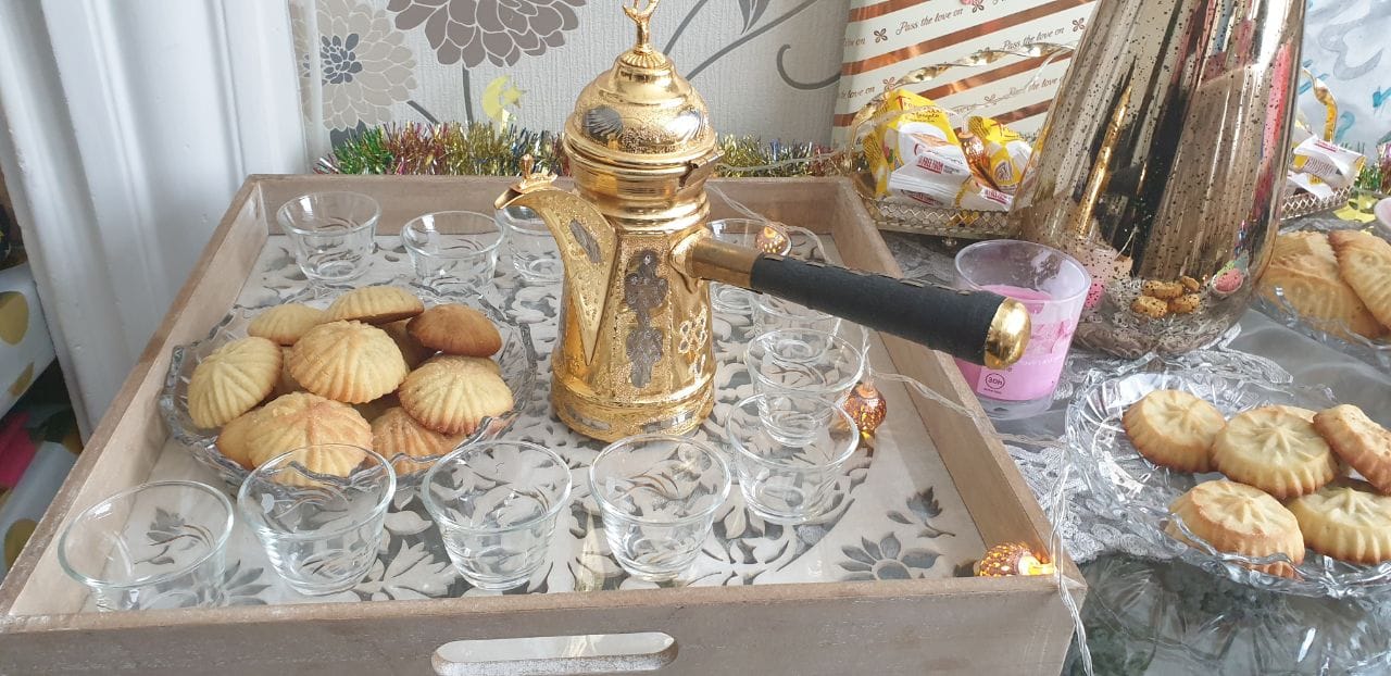 صحن معمول بجانب مصب قهوة و فناجين صغير على صينية