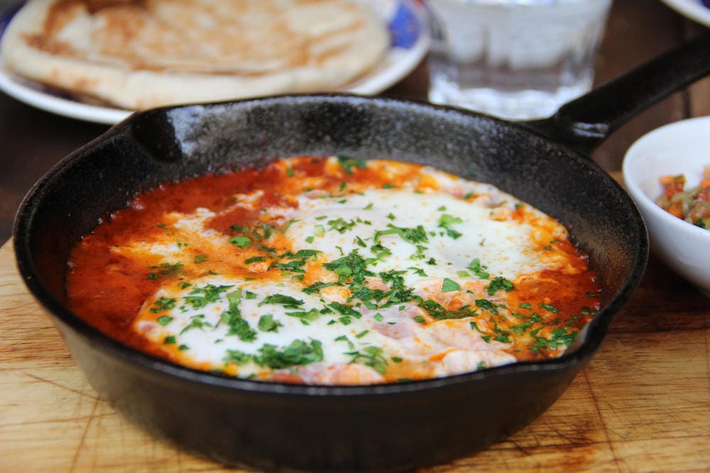 مقلاة فيها بندورة و بيض و بقدونس. شكشوكة