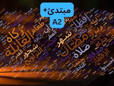 في منتصف الصورة كلمات مبتدئ و (ِA2) بخلفية زرقاء. و غيمة كلمات عن شهر رمضان. خلفية الكلمات بنية غامقة مع قليل من البرتقالي. الكلمات بألوان مختلفة أغلبتها قريب من البني. من الكلمات في الصورة: رَمَضَان، العائلة، زكاة، إفطار، صلاة، شهر صدقة... وغيرها كثير.